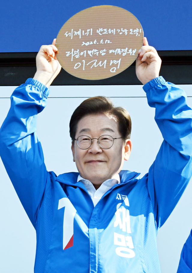 이재명 더불어민주당 대선 후보가 공식 선거운동 시작일인 12일 경기 화성시 동탄 센트럴파크에서 'K-반도체' 동탄 집중유세를 하며 '세계 1위 반도체 강국 도약!'이라 적고 서명한 웨이퍼를 들어보이고 있다. 화성=오승현 기자