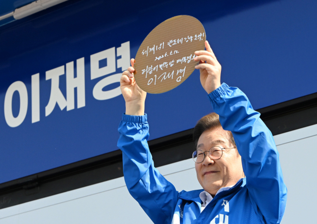 이재명 더불어민주당 대선 후보가 공식 선거운동 시작일인 12일 경기 화성시 동탄 센트럴파크에서 'K-반도체' 동탄 집중유세를 하며 '세계 1위 반도체 강국 도약!'이라 적고 서명한 웨이퍼를 들어보이고 있다. 화성=오승현 기자