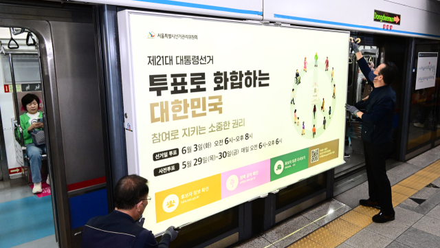 14일 서울 지하철 4호선 혜화역 하행선 승강장에서 서울특별시 선거관리위원회 관계자들이 제21대 대통령 선거 홍보물을 설치하고 있다. 권욱 기자 2025.5.14