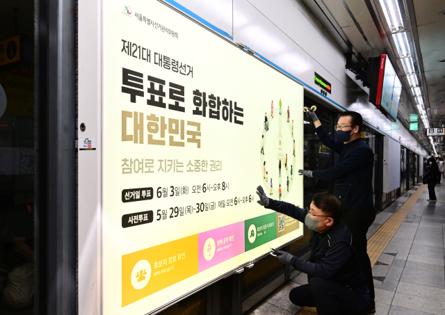 14일 서울 지하철 4호선 혜화역 하행선 승강장에서 서울특별시 선거관리위원회 관계자들이 제21대 대통령 선거 홍보물을 설치하고 있다. 권욱 기자 2025.5.14