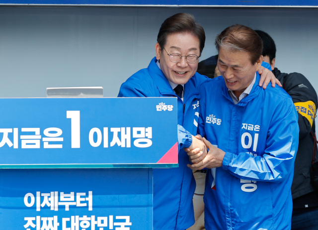 이재명(왼쪽) 더불어민주당 대선 후보가 13일 경북 구미역 광장에서 선거 유세를 하면서 권오을 선대위 국민대통합위원장과 악수하고 있다. 구미 = 연합뉴스