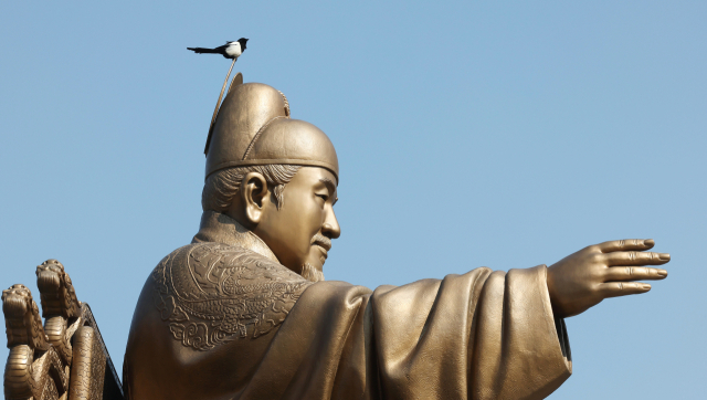 서울 광화문광장 세종대왕 동상에 까치가 잠시 내려앉아 있다. 연합뉴스