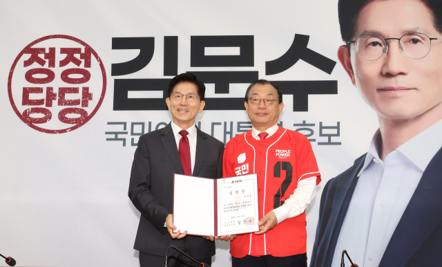 김문수 국민의힘 대선 후보(왼쪽)가 15일 국회에서 열린 중앙선거대책위원회 회의 및 임명장 수여식에서 이정현 공동선대위원장에게 임명장을 전달한 뒤 기념 사진을 촬영하고 있다. 연합뉴스
