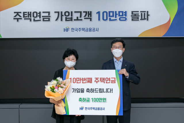 지난 2022년 주택연금에 10만 번째 가입한 가입자(왼쪽)가 기념촬영을 하고 있다. 사진 제공=한국주택금융공사 제공