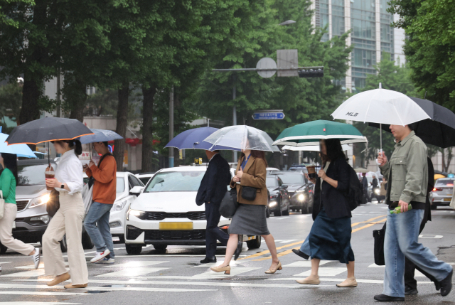 15일 서울 광화문 부근에서 시민들이 우산을 쓰고 이동하고 있다. 이날 기상청은 전국이 대체로 흐리고 오전에 비가 내릴 것으로 예보했다. 연합뉴스