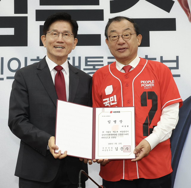 김문수(왼쪽) 국민의힘 대선 후보가 15일 국회에서 열린 중앙선대위 회의에서 이정현 공동선대위원장에게 임명장을 수여한 뒤 기념촬영을 하고 있다. 성형주 기자