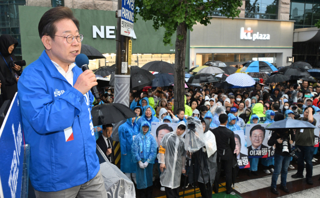 이재명 더불어민주당 대선 후보가 15일 쏟아지는 비에도 불구하고 수많은 인파가 운집한 전남 순천시 연향동 패션의거리에서 지지를 호소하고 있다. 순천=오승현 기자 2025.05.15