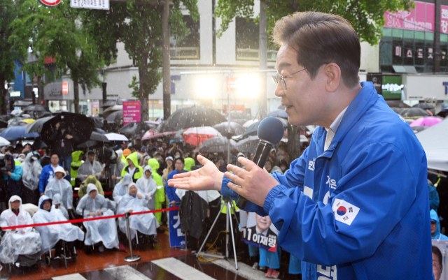 이재명 더불어민주당 대선 후보가 15일 쏟아지는 비에도 불구하고 수많은 인파가 운집한 전남 순천시 연향동 패션의거리에서 지지를 호소하고 있다. 순천=오승현 기자