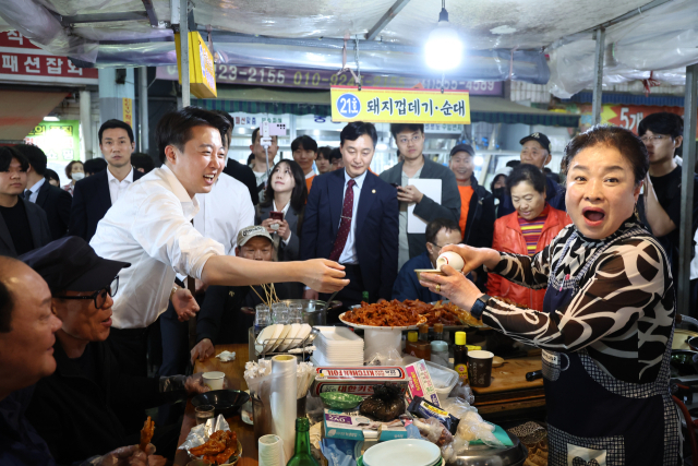 이준석 개혁신당 대선 후보가 16일 충남 천안중앙시장에서 유세 도중 한 상인이 건넨 막걸리를 받고 있다. 연합뉴스