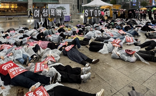 17일 서울 지하철 2호선 강남역 10번 출구 인근에서 ‘강남역 살인사건’ 추모제 참석자들이 다이인(die-in·죽은 것처럼 드러눕는 시위) 퍼포먼스를 하고 있다. 연합뉴스