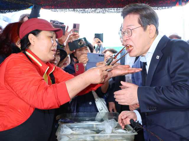 이재명 더불어민주당 대선 후보가 10일 경남 함안군 가야전통시장에서 김치를 맛보고 있다. 연합뉴스
