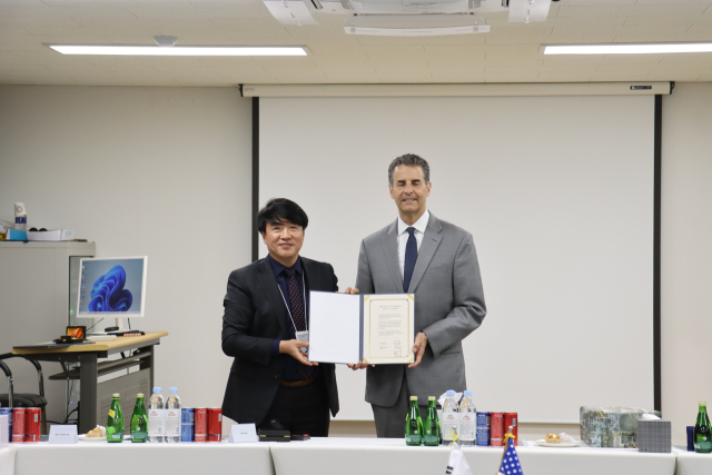 정홍구(왼쪽) 엔켐 사장이 16일 천안 사업장에서 존 사베인스 전 미국 연방하원의원에게 감사패를 전달하고 있다. 사진 제공=엔켐