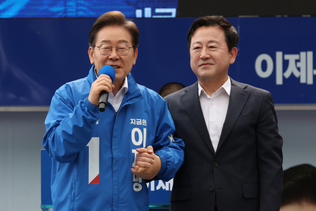 더불어민주당 이재명 대선후보가 17일 광주광역시 서구 김대중컨벤션센터 광장에서 열린 집중 유세에서 이 후보 지지를 선언한 김용남 전 의원을 소개하고 있다. / 연합뉴스