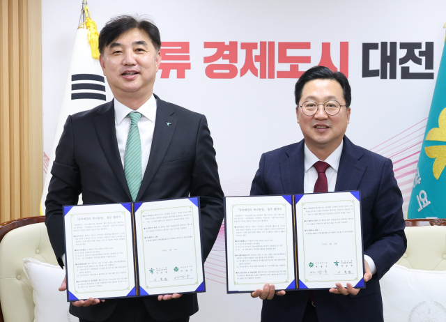 이장우(오른쪽) 대전시장과 이동렬(왼쪽) 하나은행 충청영럽그룹 부행장이 ‘꿈씨패밀리 하나통장’출시 업무협약을 체결하고 기념촬영을 하고 있다. 사진제공=대전시