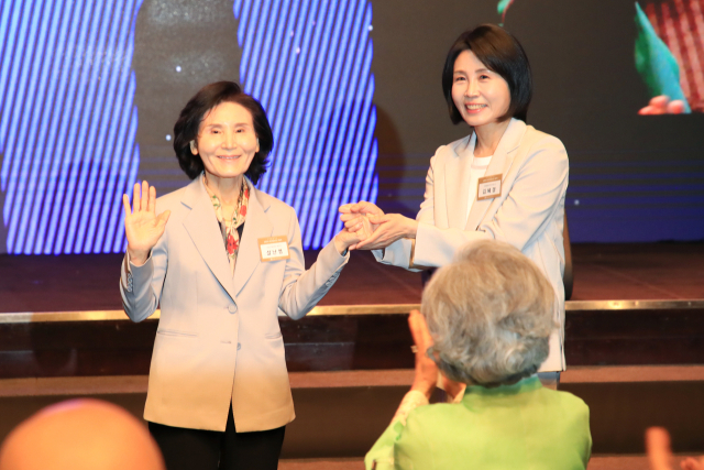 이재명 더불어민주당 대통령 후보의 부인 김혜경(오른쪽) 여사와 김문수 국민의힘 대통령 후보의 부인 설난영 여사가 지난 12일 서울 중구 신라호텔에서 열린 중앙신도회 창립 70주년 기념식에 참석해 손을 잡고 있다. 사진 제공=조계종