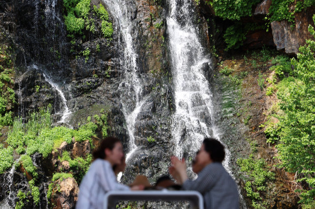 20일 서울 서대문구 홍제폭포 산책로에 설치된 대형 거울에 폭포가 흐르는 모습이 비치고 있다. 이날 경기 안성, 충청 옥천 등 일부 지역은 낮 최고기온이 30도 이상으로 오르면서 초여름 날씨를 기록했다. 연합뉴스