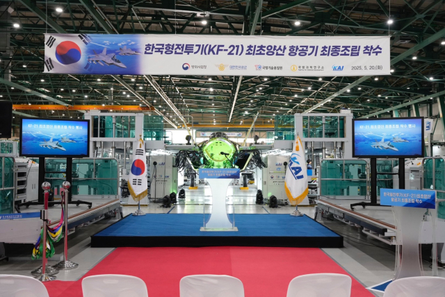 KF-21 양산 1호기의 최종 조립 단계 착수를 기념하는 행사장 뒤로 조립 중인 KF-21의 모습이 보인다. 사진제공=KAI