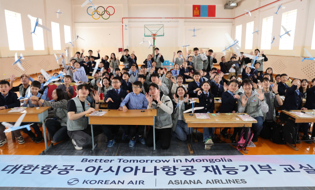 대한항공과 아시아나항공 임직원들이 21일 몽골 울란바토르시 바가노르구에 위치한 군갈루타이 국립학교에서 진행한 항공공학 체험 수업 중 함께 만든 비행기 모형을 날리고 있다. 울란바토르=권욱 기자