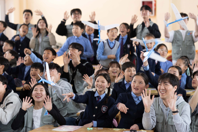 대한항공과 아시아나항공 임직원들이 21일 몽골 울란바토르시 바가노르구에 위치한 군갈루타이 국립학교에서 진행한 항공공학 체험 수업 중 참여 학생들과 함께 만든 비행기 모형을 날리고 있다. 울란바토르=권욱 기자