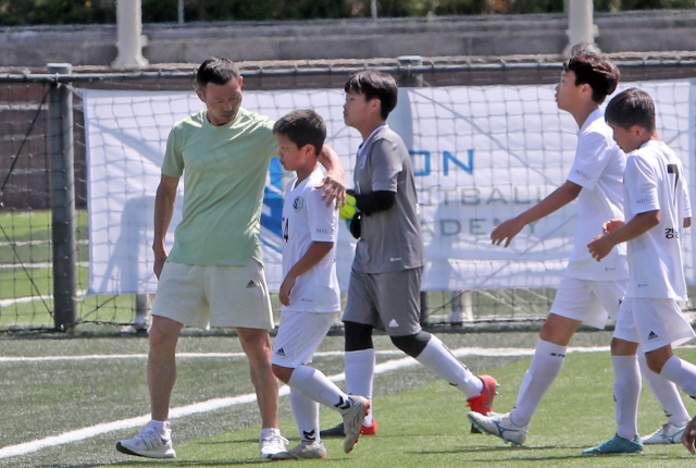 2022년 6월 8일 강원 춘천시 동면 감정리 손흥민 체육공원에서 ‘손흥민 국제유소년친선축구대회’가 진행된 가운데, 손웅정 손축구 아카데미 감독(왼쪽)이 전반 경기를 마치고 들어오는 선수들을 격려하고 있다. 연합뉴스