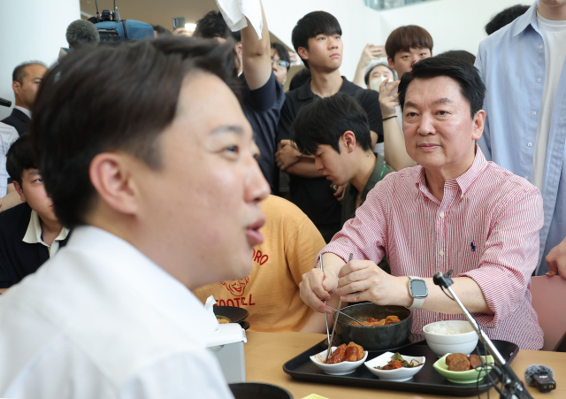 안철수 국민의힘 공동선거대책위원장이 21일 경기 성남시 가천대학교 글로벌캠퍼스에서 열린 '학식 먹자 이준석' 행사에 참석한 가운데 학생들과 대화를 나누는 이준석 개혁신당 대선 후보를 바라보고 있다. 연합뉴스