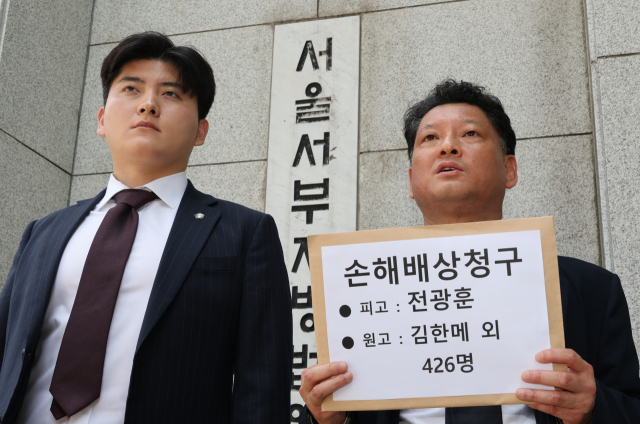 사법정의바로세우기시민행동 김한메 상임대표(오른쪽)와 법률대리인인 박강운 변호사가 21일 서울 마포구 서울서부지방법원 앞에서 사랑제일교회 전광훈 목사의 내란 및 폭력 선동 행위에 대한 정신적 피해 손해배상 청구 소송에 앞서 기자회견을 하고 있다. 연합뉴스