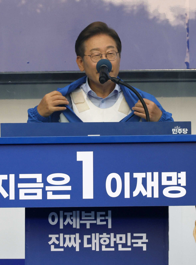 이재명 더불어민주당 대선 후보가 21일 자신의 지역구인 인천 계양구 계양역에서 연설하던 중 착용 중인 방탄복을 보이고 있다. 인천=오승현 기자 2025.05.21