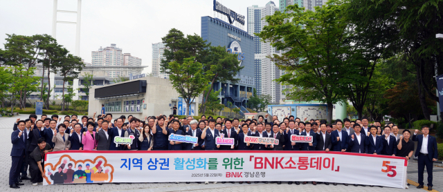 김태한 BNK경남은행 은행장과 임직원, 창원시 공무원들이 점심 식사에 앞서 창원NC파크 앞에서 '지역 상권 활성화를 위한 BNK소통데이' 현수막을 들고 단체 기념 촬영을 하고 있다. 사진 제공=BNK경남은행