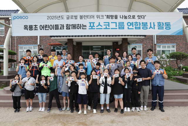 포스코그룹의 봉사 축제 '2025년 글로벌 볼런티어 위크'를 맞아 장인화(가운데줄 왼쪽 다섯 번째) 포스코그룹 회장이 광양시 옥룡초등학교 학생들과 함께 전통 한지로 태극기를 만든 후 기념 촬영을 하고 있다. 사진 제공=포스코홀딩스