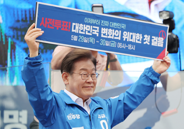 이재명 더불어민주당 대선 후보가 22일 경남 양산워터파크공원에서 열린 집중 유세에서 ‘사전투표! 대한민국 변화의 위대한 첫 걸음’이라고 적힌 현수막을 들어 보이고 있다. 연합뉴스