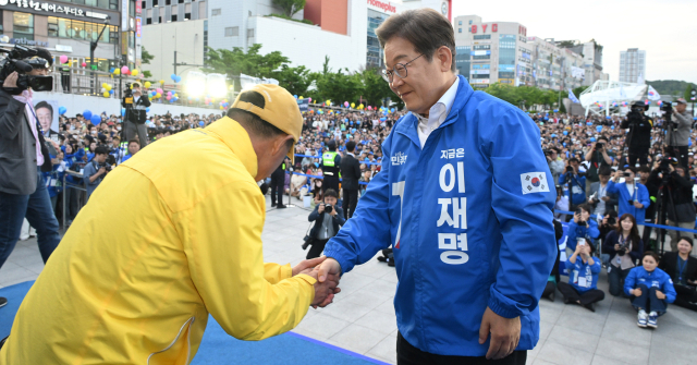 이재명 더불어민주당 대선 후보가 24일 경기 안산시 안산문화광장에서 연설하기 전 세월호 유족과 인사하고 있다. 안산=오승현 기자 2025.05.24