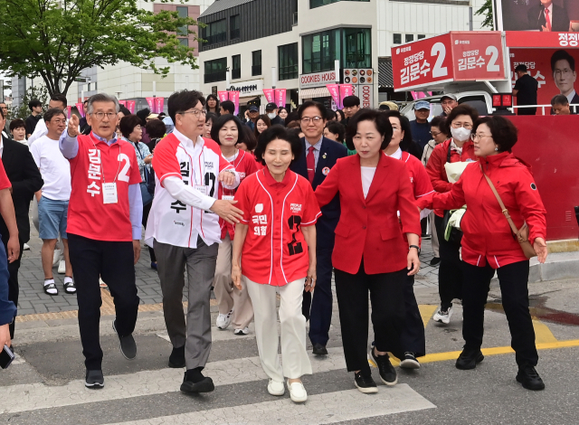 23일 강원 강릉시 중앙시장 일원에서 국민의힘 김문수 대선 후보의 배우자 설난영(앞줄 오른쪽 세번째) 여사가 권성동 원내대표와 유권자들을 만나기 위해 횡단보도를 건너고 있다. 연합뉴스