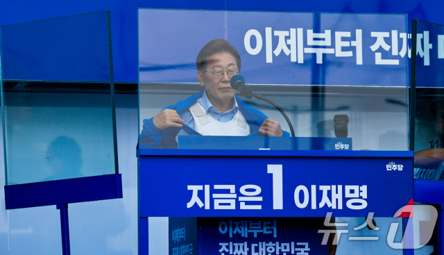 이재명 더불어민주당 대통령 후보가 21일 오후 자신의 지역구인 인천 계양구 계양역을 찾아 유세 중 본인이 착용한 방탄조끼를 보여주고 있다. 뉴스1