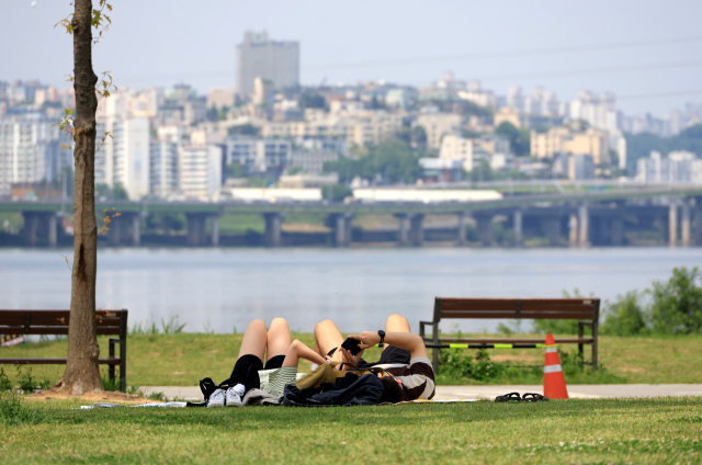 화창한 날씨가 이어진 26일 서울 한강공원을 찾은 시민들이 그늘을 찾아 휴식하고 있다. 연합뉴스