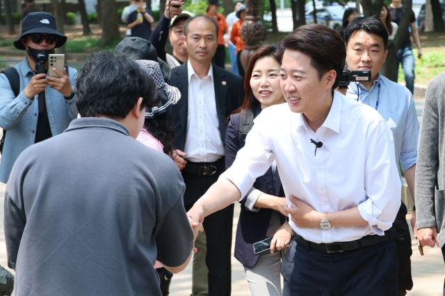 이준석(오른쪽) 개혁신당 대선 후보가 28일 서울 여의도공원에서 점심시간을 이용해 산책 나온 직장인과 악수를 하고 있다. 연합뉴스
