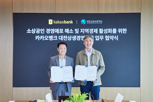 양필환(왼쪽) 대전신용보증재단 이사장과 김석(오른쪽) 카카오뱅크 부행장과 업무협약을 체결하고 기념촬영을 하고 있다. 사진제공=대전신용보증재단