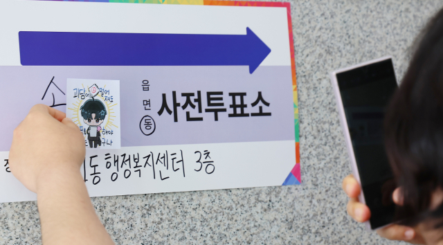 제21대 대통령 선거 사전투표 첫날인 29일 인천 연수구 송도1동 행정복지센터에 마련된 사전투표소에서 투표를 마친 유권자가 투표 도장이 찍힌 그림을 들고 기념 촬영을 하고 있다. 연합뉴