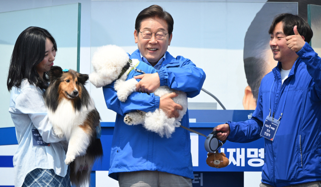 이재명 더불어민주당 대선 후보가 30일 강원 춘천시 춘천역 광장에서 연설 시작 전 강원도에 사는 강아지 토리·뭉치를 안고 지지를 호소하는 퍼포먼스를 하고 있다. 이 후보는 공식 선거운동이 시작된 후 처음으로 강원지역을 방문했다. 춘천=오승현 기자 2025.05.30