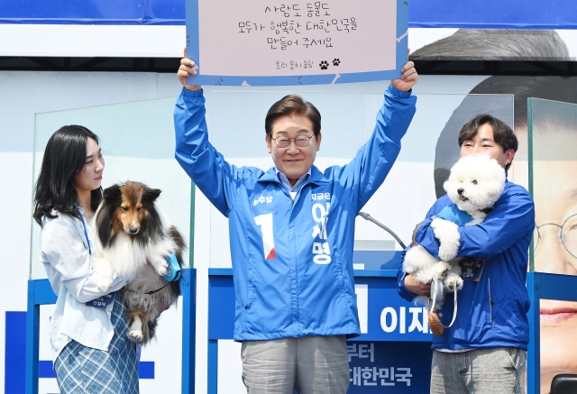 이재명 더불어민주당 대선 후보가 30일 강원 춘천시 춘천역 광장에서 연설 시작 전 강원도에 사는 강아지 토리·뭉치와 지지를 호소하는 퍼포먼스를 하고 있다. 이 후보는 공식 선거운동이 시작된 후 처음으로 강원지역을 방문했다. 춘천=오승현 기자 2025.05.30