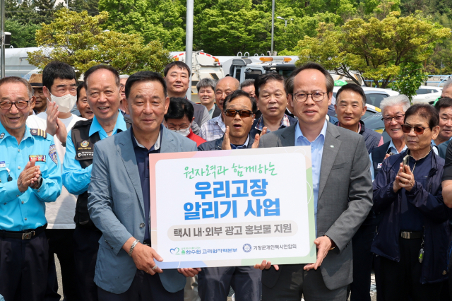 남영규(오른쪽) 고리원자력본부 대외협력처장(오른쪽)과 강철진 기장군개인택시연합회장이 ‘원자력과 함께하는 우리고장 알리기 사업 전달식’ 행사 관계자들과 함께 기념 촬영을 하고 있다. 사진제공=고리원자력본부