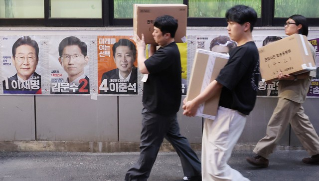 제21대 대통령선거 사전투표 둘째 날인 30일 서울 중구 소공동주민센터에 마련된 사전투표소에서 사전투표사무원들이 관내 사전투표함과 관외 사전투표지를 이송하고 있다. 연합뉴스
