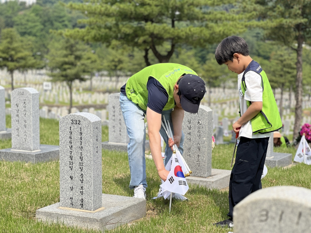 현대엔지니어링 임직원 가족이 지난달 31일 서울 동작구 국립서울현충원에서 묘역 정화 활동을 펼치고 있다. 사진 제공=현대엔지니어링