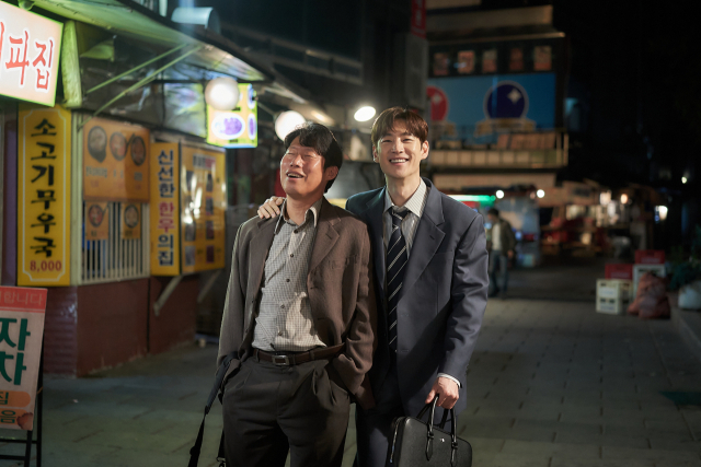 영화 '소주전쟁'의 한 장면으로 국보소주의 재무이사역 표종록 역의 유해진(왼쪽)과 글로벌 투자자문사 솔퀸의 인범 역 이제훈. 사진 제공=쇼박스
