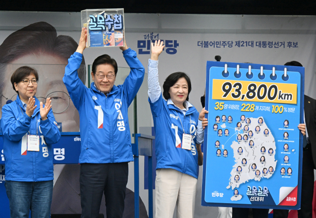 이재명(가운데) 더불어민주당 대선 후보가 2일 경기 하남시 스타필드 하남점 광장에서 연설 전 추미애 골목골목선대위 총괄선대위원장으로부터 전국 곳곳의 민심을 담은 골목수첩을 전달받아 들어보이고 있다. 하남=오승현 기자