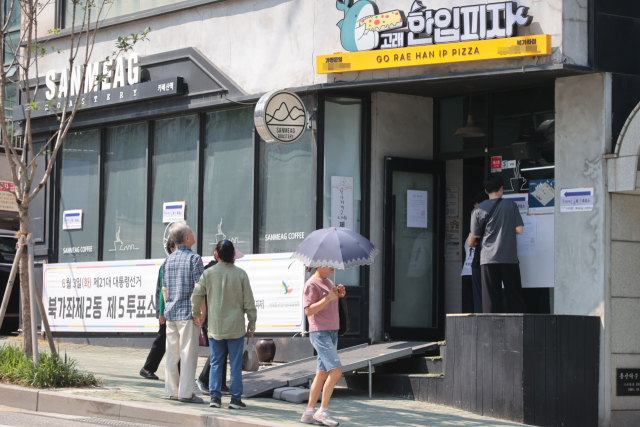 21대 대통령선거 투표일인 3일 서울 서대문구 고래한입피자 매장에 마련된 북가좌제2동 제5투표소에서 유권자들이 투표하고 있다. 연합뉴스