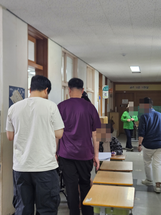 3일 윤중현 전국택배노동조합 수석부위원장이 인천 미추홀구 숭의초 투표소에 들어가기 위해 줄을 서 있다. 인천=박민주 기자