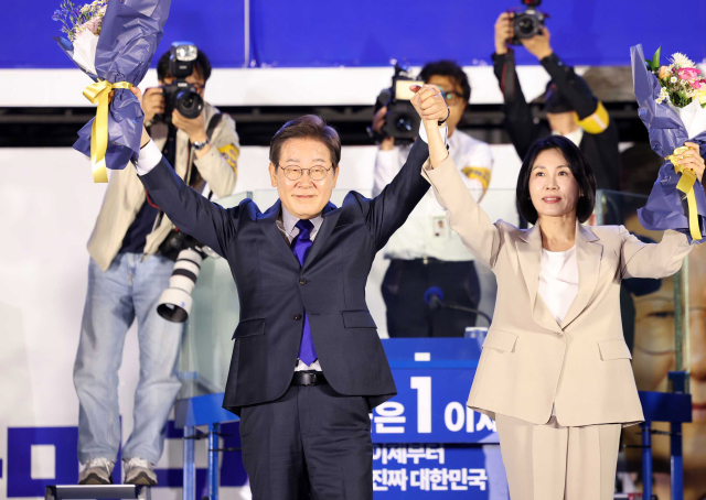 이재명 대통령이 배우자 김혜경 여사가 4일 서울 여의도 국회 앞에서 당선 축하 꽃다발을 들고 지지자들의 환호에 화답하고 있다. 오승현 기자