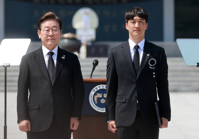 이재명 대통령이 6일 서울 동작구 국립서울현충원에서 열린 70회 현충일 추념식에서 2014년 고공 기본교육 중 부상을 입은 황해 씨에게 국가유공자 증서를 수여한 뒤 기념촬영을 하고 있다. 연합뉴스