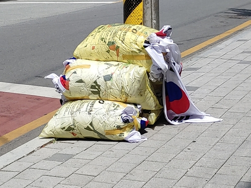 6일 충북 청주의 한 길거리에서 발견된 태극기가 담긴 쓰레기 종량제 봉투 더미. 연합뉴스