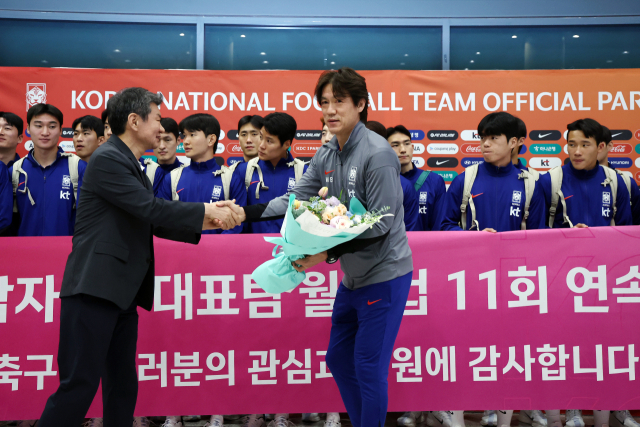 정몽규(왼쪽) 대한축구협회장이 6일 인천국제공항으로 귀국한 홍명보 대한민국 축구 대표팀 감독에게 꽃다발을 건네고 있다. 연합뉴스